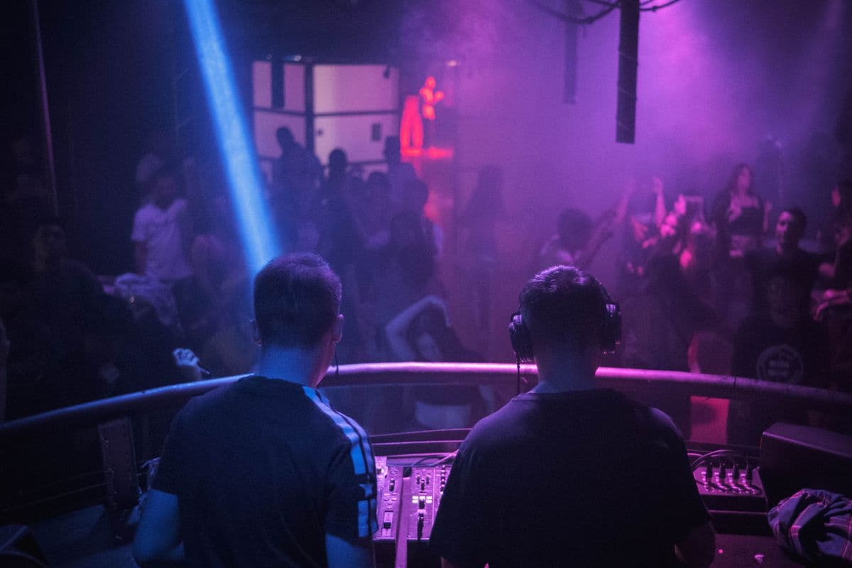 Disc-jockey de dos devant une console de mixage